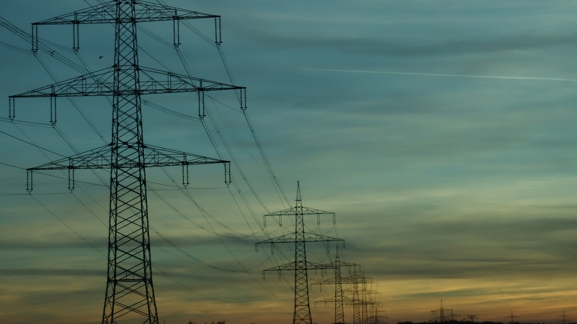 High voltage powerlines against sunset sky