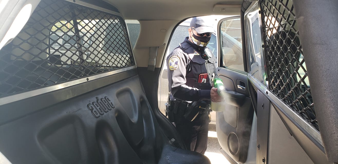 Hobbs police officer spraying cruiser with Biomist disinfectant