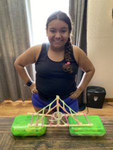 Science camp participant with bridge made of straws