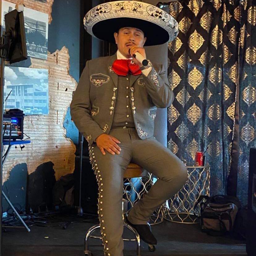 Javier Galvezy, Jr.  Mariachi singer on stool.