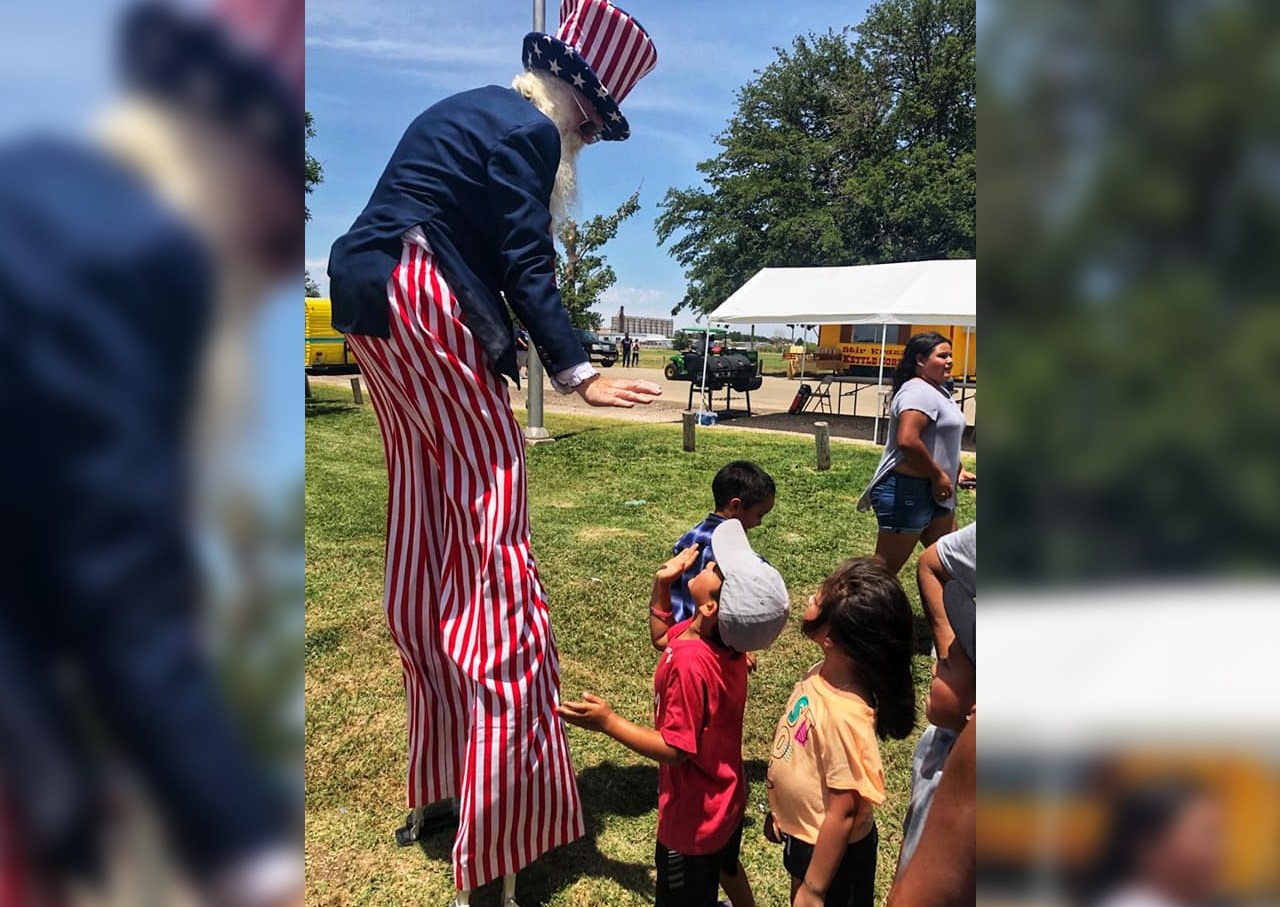 Uncle Sam with children. Stilts, blurred background.