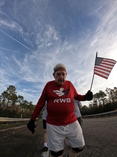 Ernie Andrus walking with American flag