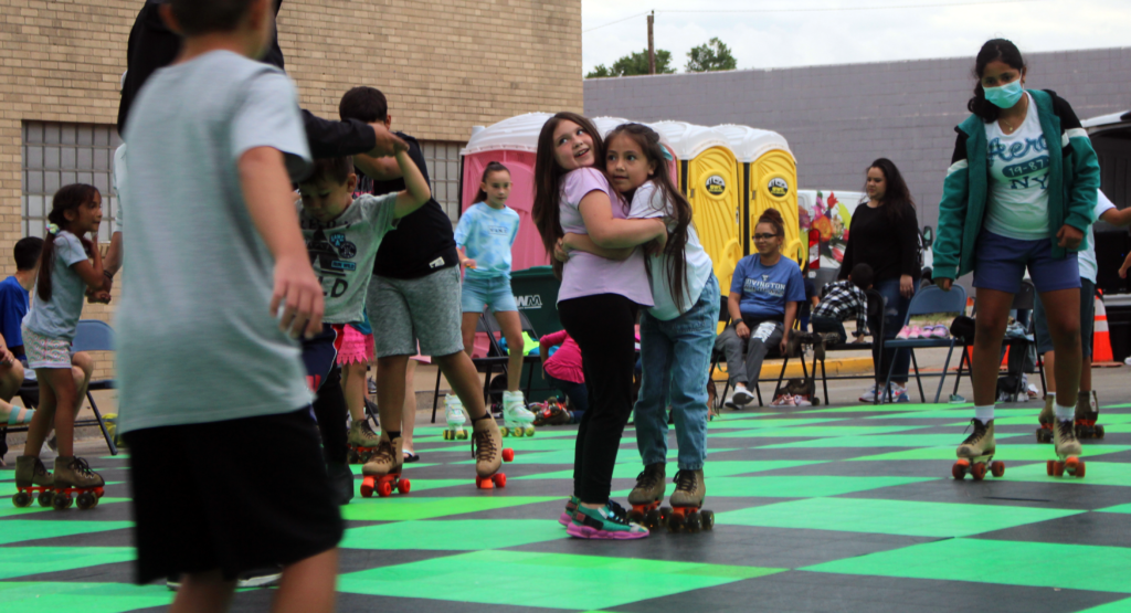 Two little girls hugging while skating